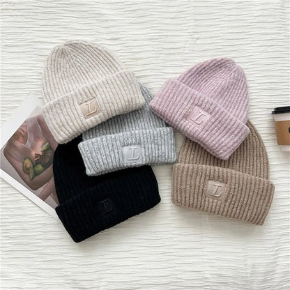 assorted cuffed beanies in neutral colors with embroidered patch detail